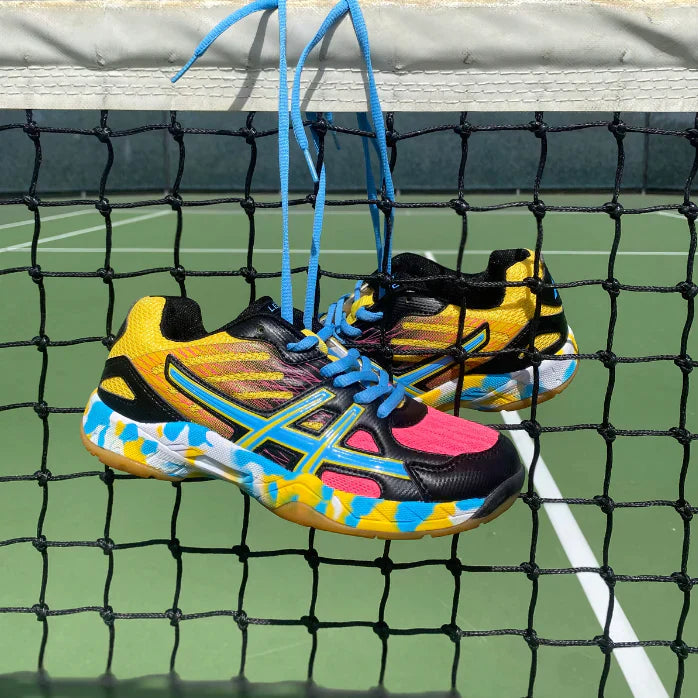 Orthopädische Tennisschuhe in Lila, mit atmungsaktivem Material und stabiler Sohle für Damen und Herren auf dem Platz.