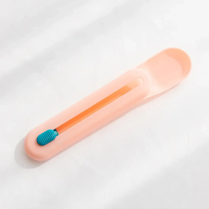 Close-up of pet food dispenser spoon with slider, showing measuring mechanism