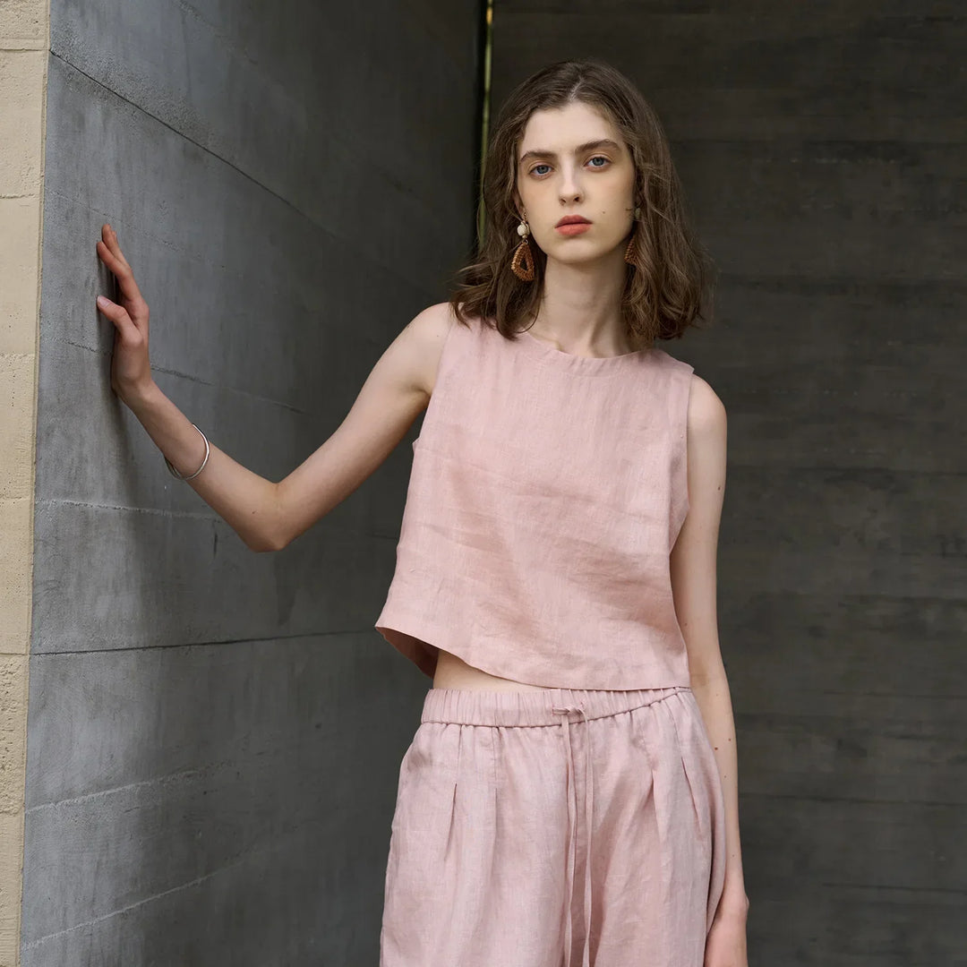 Pink women's asymmetric sleeveless crop top. Modern crew neck & stylish summer fashion for casual wear.