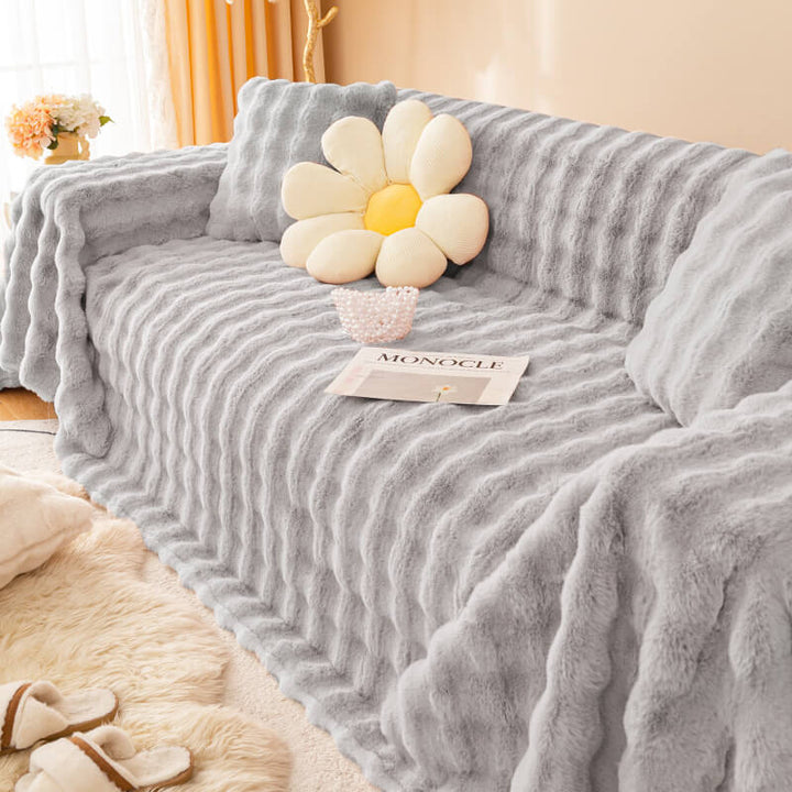 Unisex faux rabbit fur couch protector draped on a sofa, enhancing home decor with its plush texture.