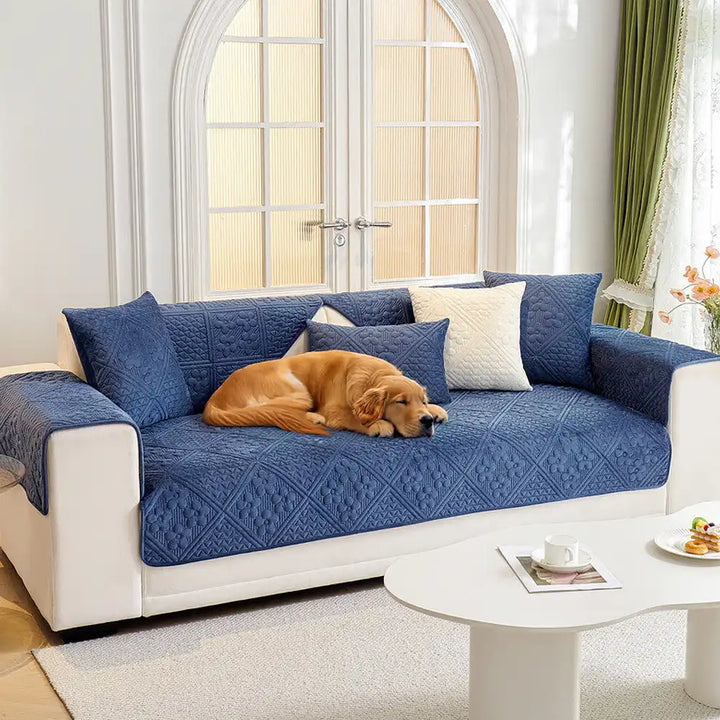 Plush geometric embossed non-slip sofa protector cover in a living room setting, pet-friendly furniture protection.