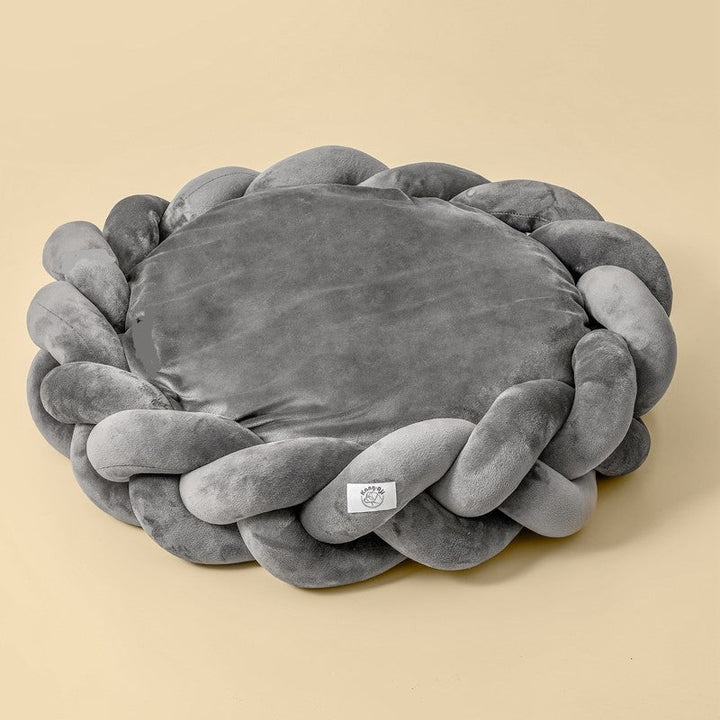 Soft bolster dog bed with unique braided detail, offering luxury and comfort for pets.