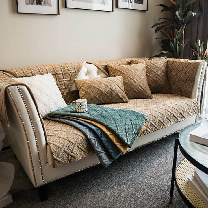 Luxurious blue quilted velvet furniture protector draped over a multi-seat sofa, adding comfort and style
