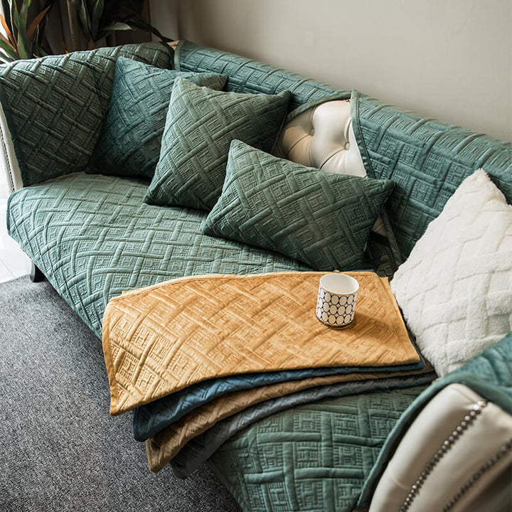 Plush velvet quilted sofa couch cover in a rich color, showing scratch-resistant fabric texture.