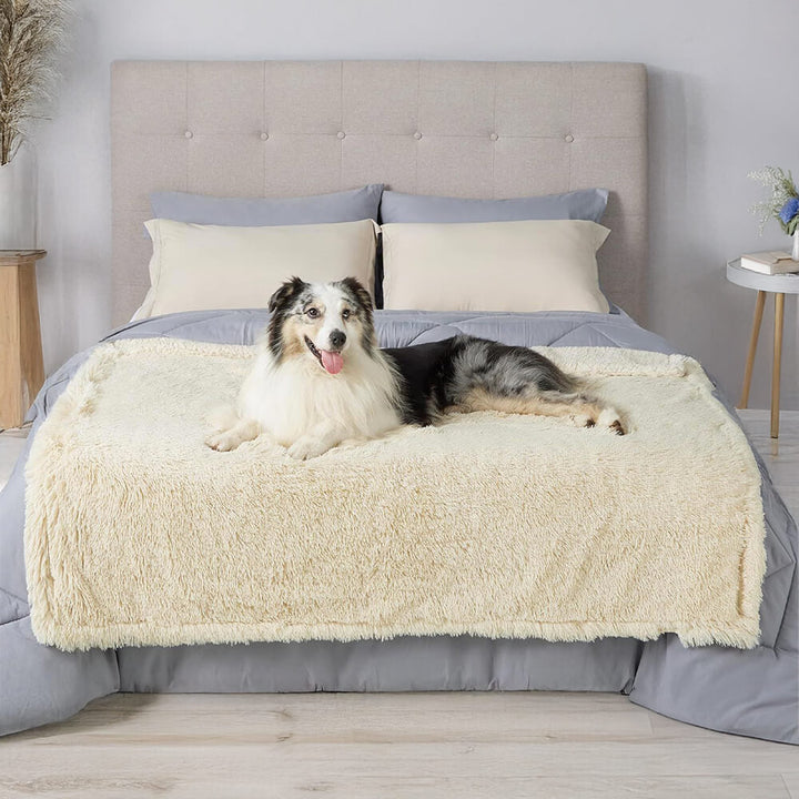 Happy dog napping comfortably on a plush, waterproof pet throw blanket on a wooden floor