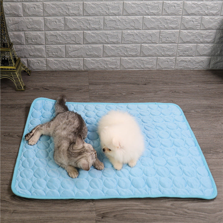 Small dog relaxing comfortably on a portable self-cooling blue pet mat, indoor use