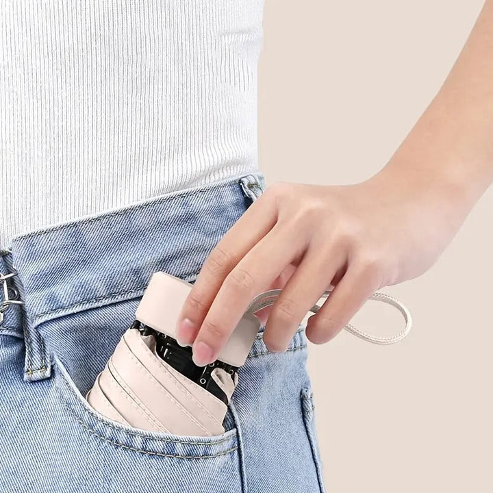 Foldable pocket umbrella for travel, mini & portable, offers wind & sun protection.