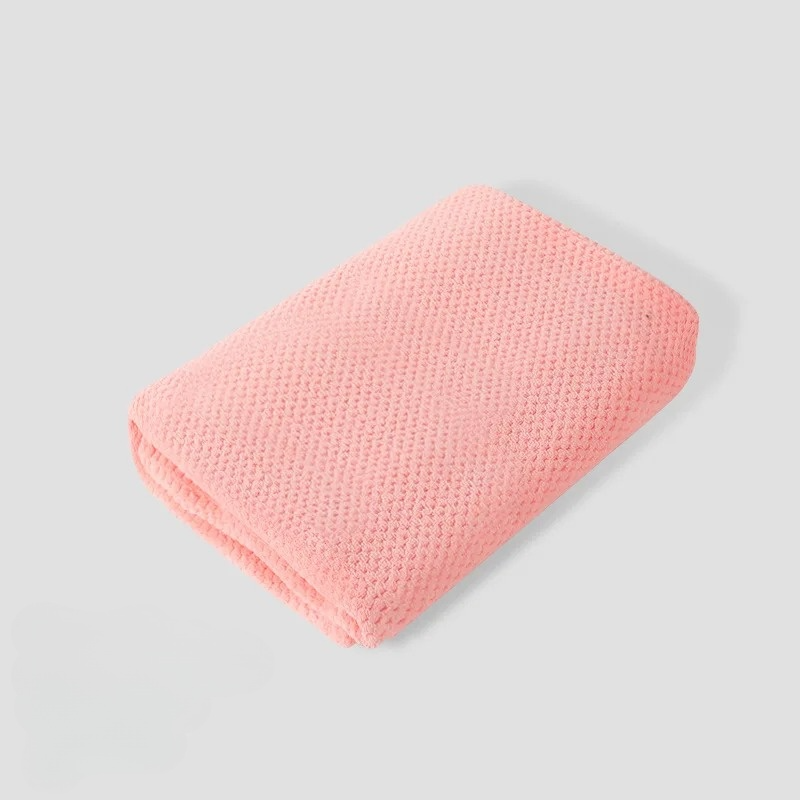Pet dog comfortably resting on a plush coral fleece blanket, showing its use for pet comfort.