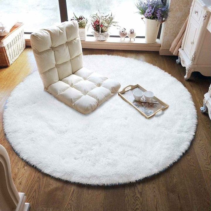 Soft gray faux fur round area rug, fluffy shaggy texture for modern bedroom decor.