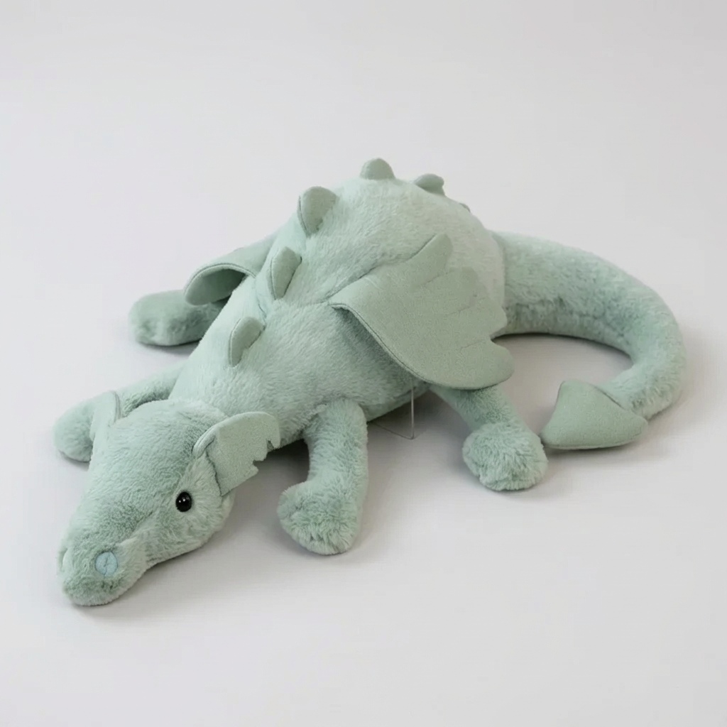 Soft green dragon plush toy with shiny wings, perfect for kids' imaginative play and cuddles. A magical stuffed animal.