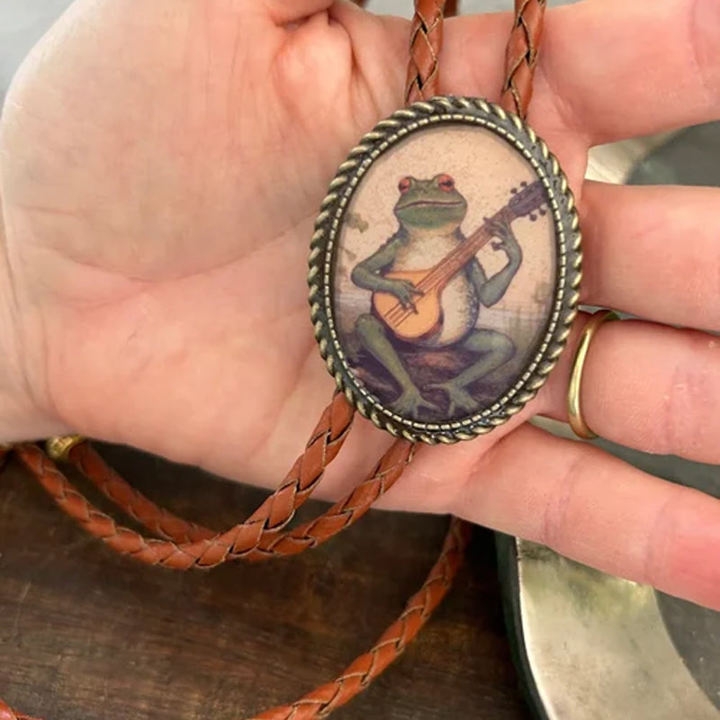 "Unisex Bolo Krawatte mit Banjo Frosch Design; stilvolles Accessoire, verstellbare Lederbänder, moderner Look."