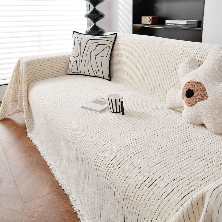 Unisex chenille sofa cover in a neutral hue, draped over a couch, offering all-season furniture protection