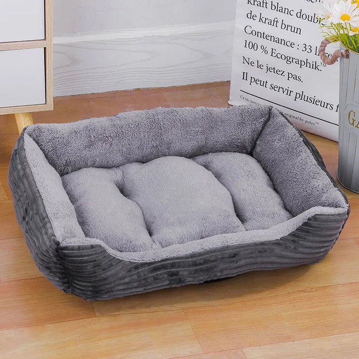 Stylish gray bolster pet bed offering waterproof protection and cozy warmth for pets in winter.