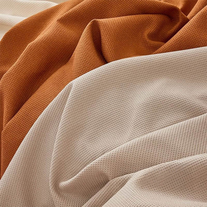 Detailed view of the elastic straps and non-slip backing of a waterproof sectional couch cover.