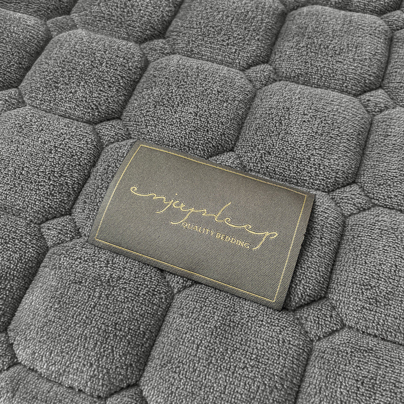 "Weiche Tagesdecke mit quadratischer Textur, flauschig und modern auf Sofa drapiert, verleiht stilvolle Gemütlichkeit."