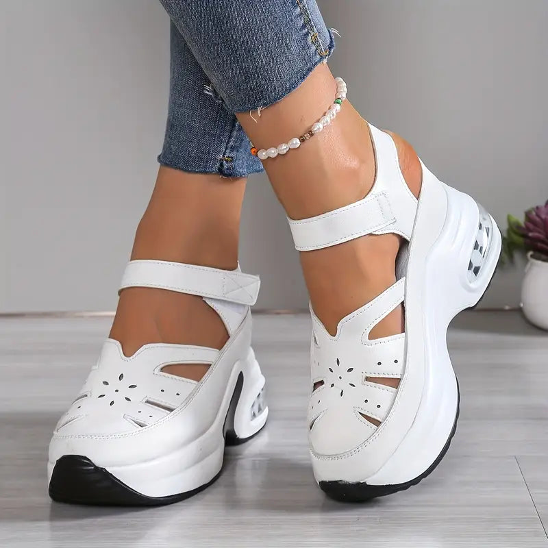 Close-up of white women's cushioned wedge sandals, showcasing breathable cutouts, platform, and adjustable strap.