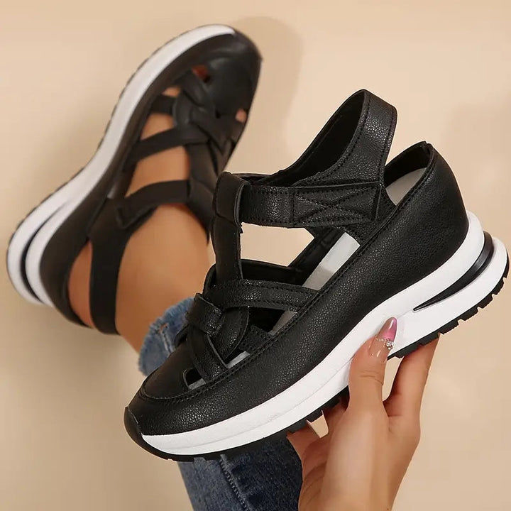 Black flatform sport sandals for women, featuring a comfortable cut-out design & adjustable velcro strap.
