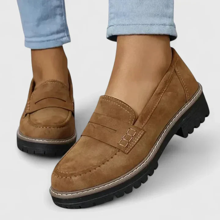 Elegant women's chunky platform penny loafers with a robust lug sole, embodying modern versatile style.