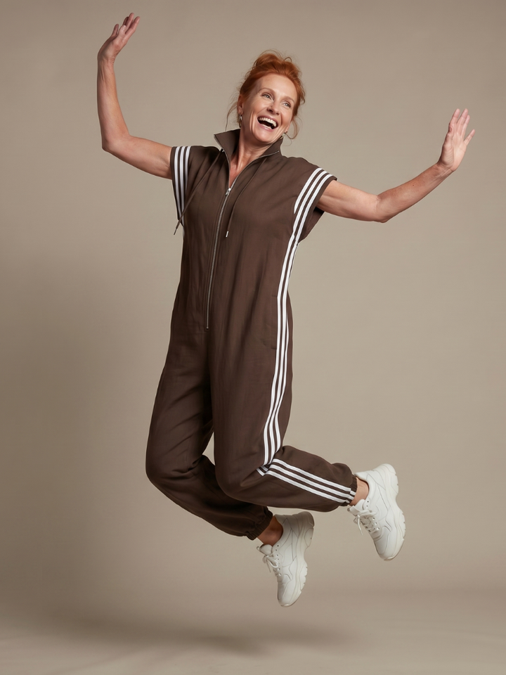 Stylish women's zip front jumpsuit with cap sleeves, full length, and eye-catching sporty side stripes.