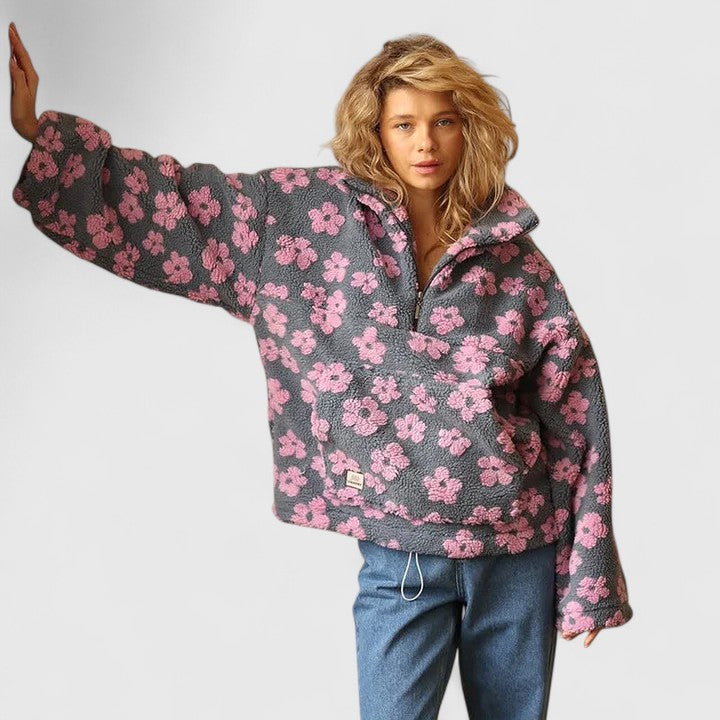 Stylish women's oversized knit sweater with vibrant floral print and quarter-zip.