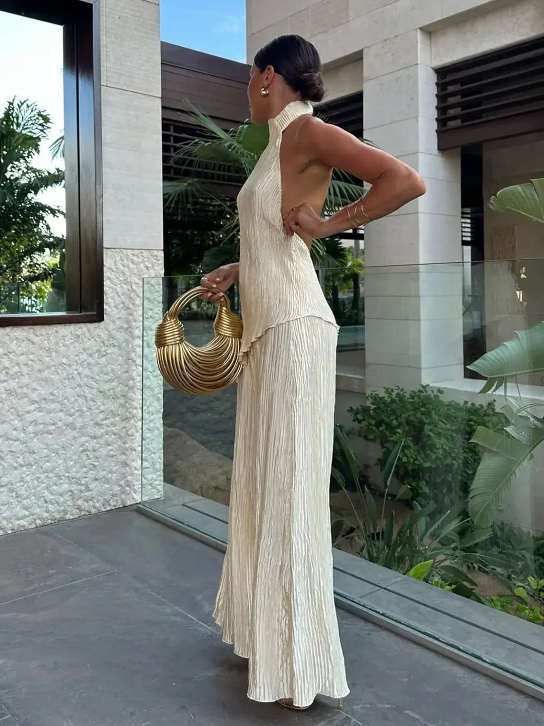 Women's stylish pleated halter crop top and wide-leg pants matching set. Fashionable summer outfit.
