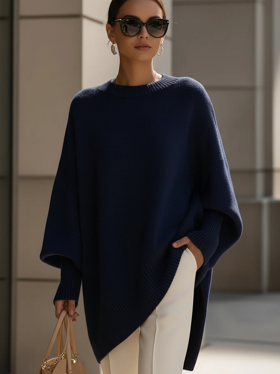 Close-up of elegant knit on women's oversized cape sweater poncho with stylish batwing sleeves.