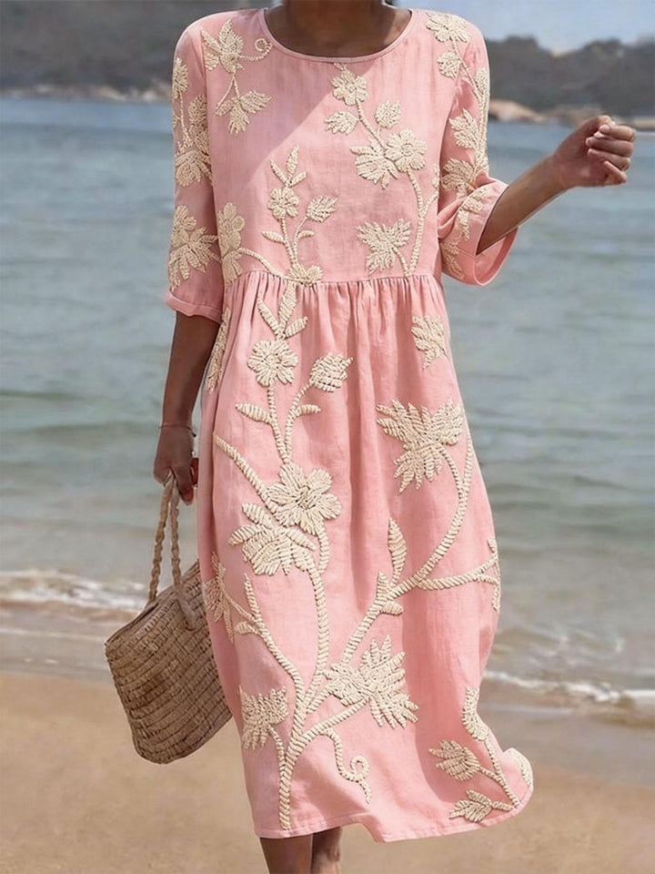 Flowing women's maxi dress with intricate floral embroidery, round neck, and 3/4 sleeves for casual wear.