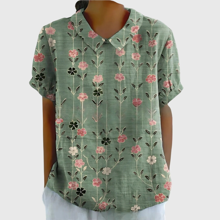 Close-up of women's floral print collared blouse fabric, showing vibrant pattern and button details.