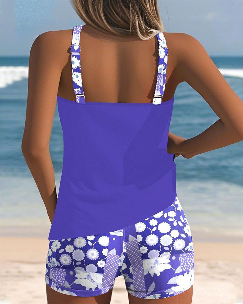 Woman enjoying beach in a vibrant floral print racerback tankini swimsuit set. Great summer beachwear.