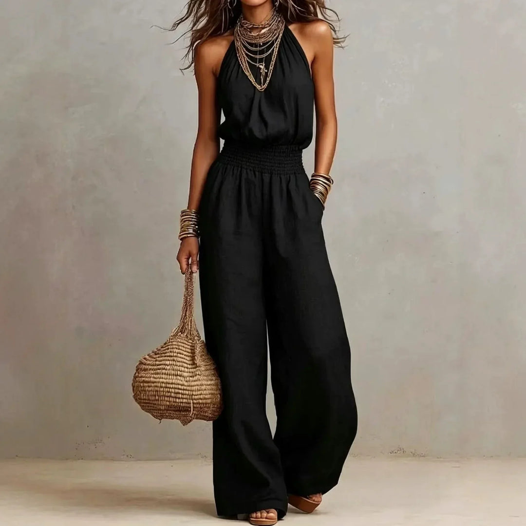 Woman posing in a stylish wide leg halter jumpsuit, a comfortable one-piece perfect for summer elegance.