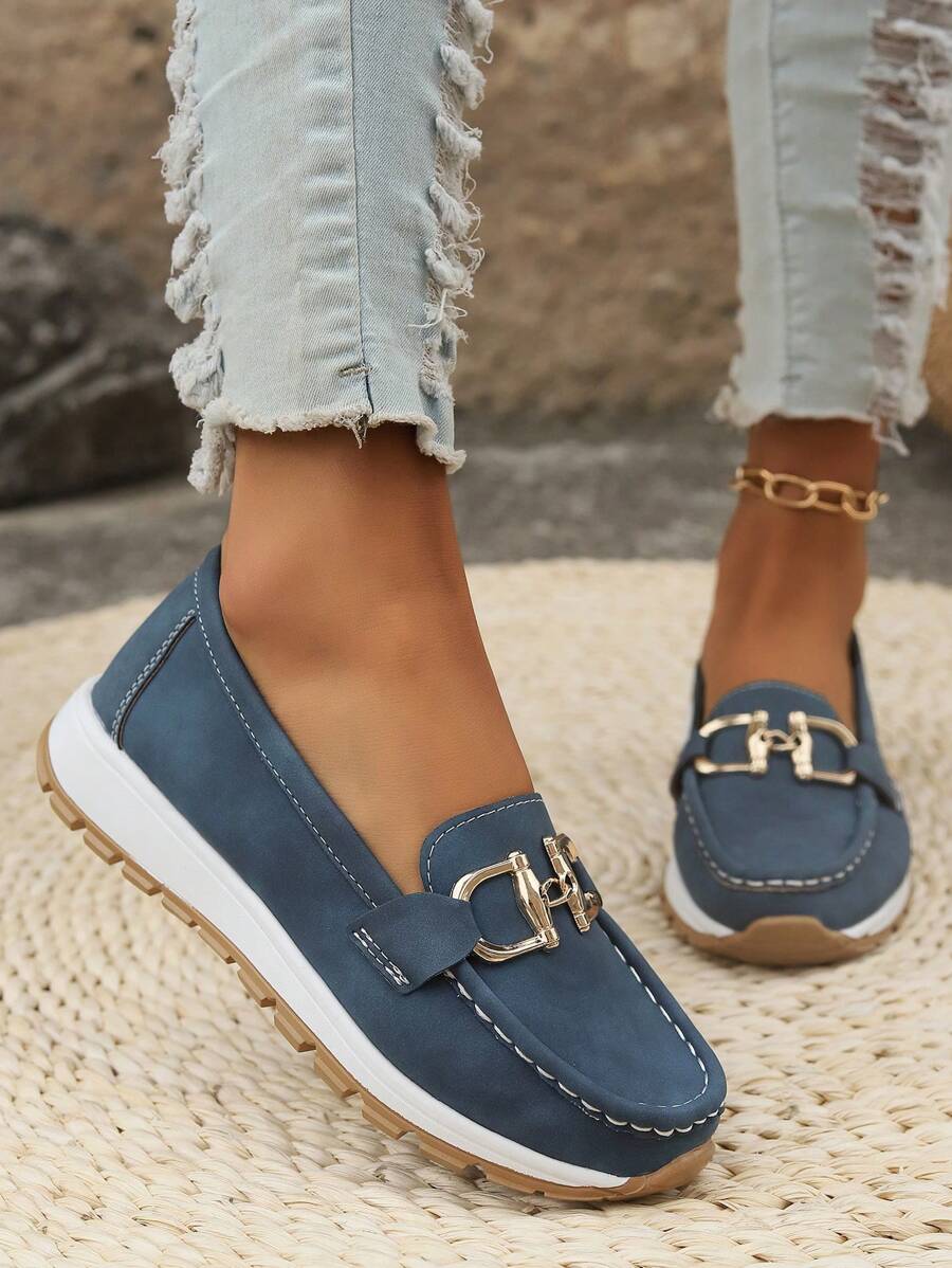 Woman wearing gold chain flatform loafers with casual chic outfit. Versatile slip-on shoes for spring summer fashion.