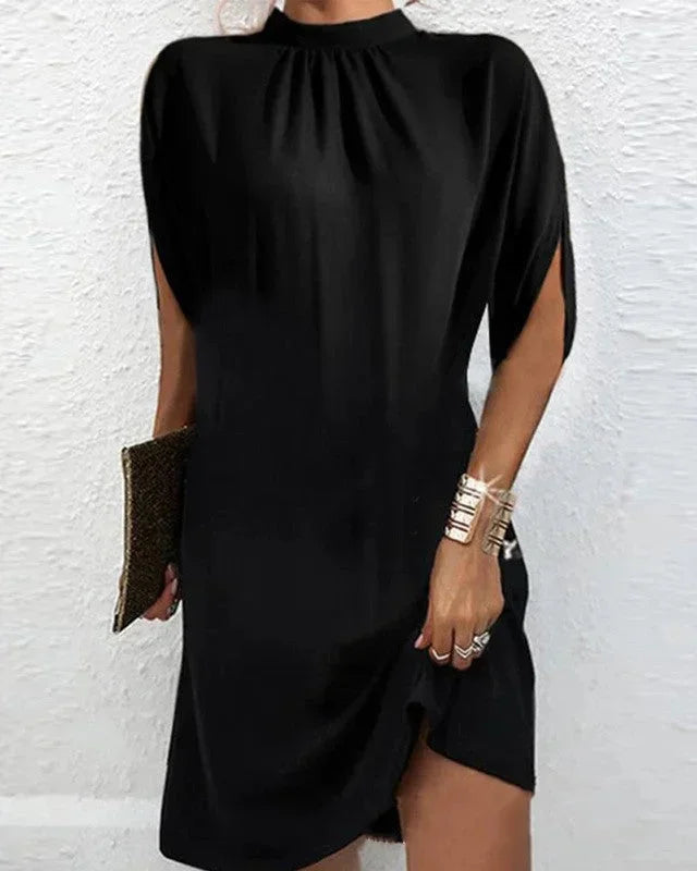 Elegant asymmetric hem mini dress for women with a sophisticated mock neck & flowing cape sleeves.