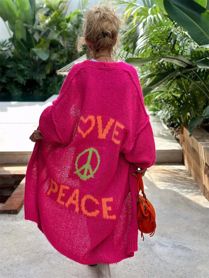 Faye women's long oversized bohemian knit cardigan with 'Love Peace' slogan and colorful pattern.