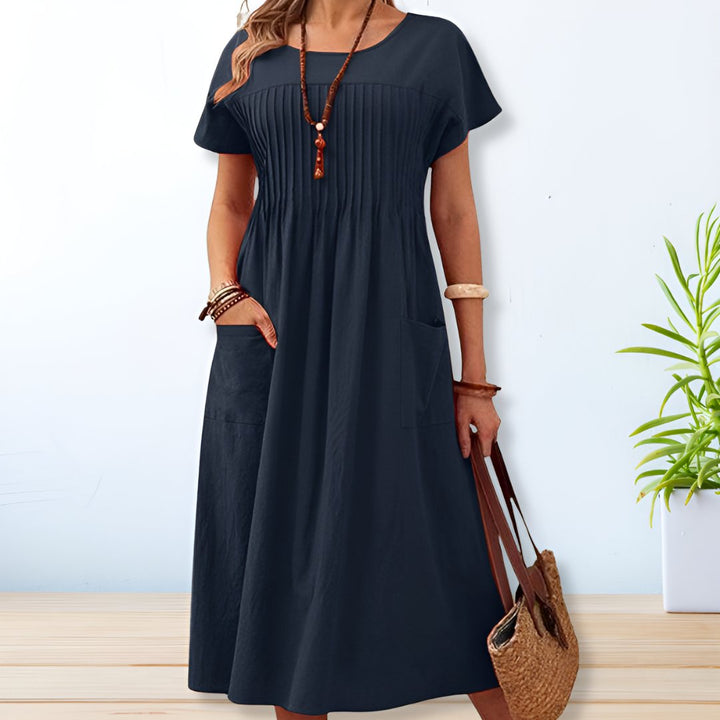 Stylish women's relaxed fit midi dress featuring a flattering silhouette, short sleeves, and essential pockets for casual wear.