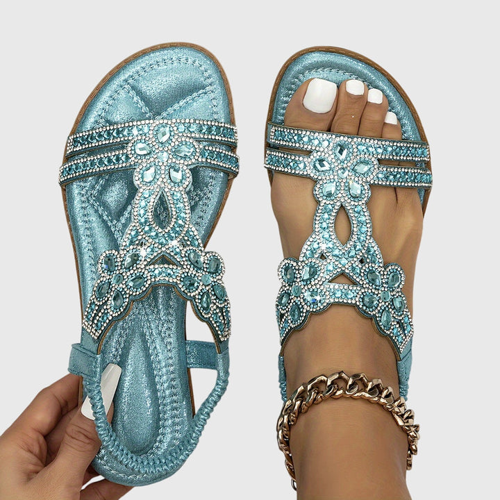 Comfortable women's slip-on flat sandals with sparkling rhinestone embellishments.