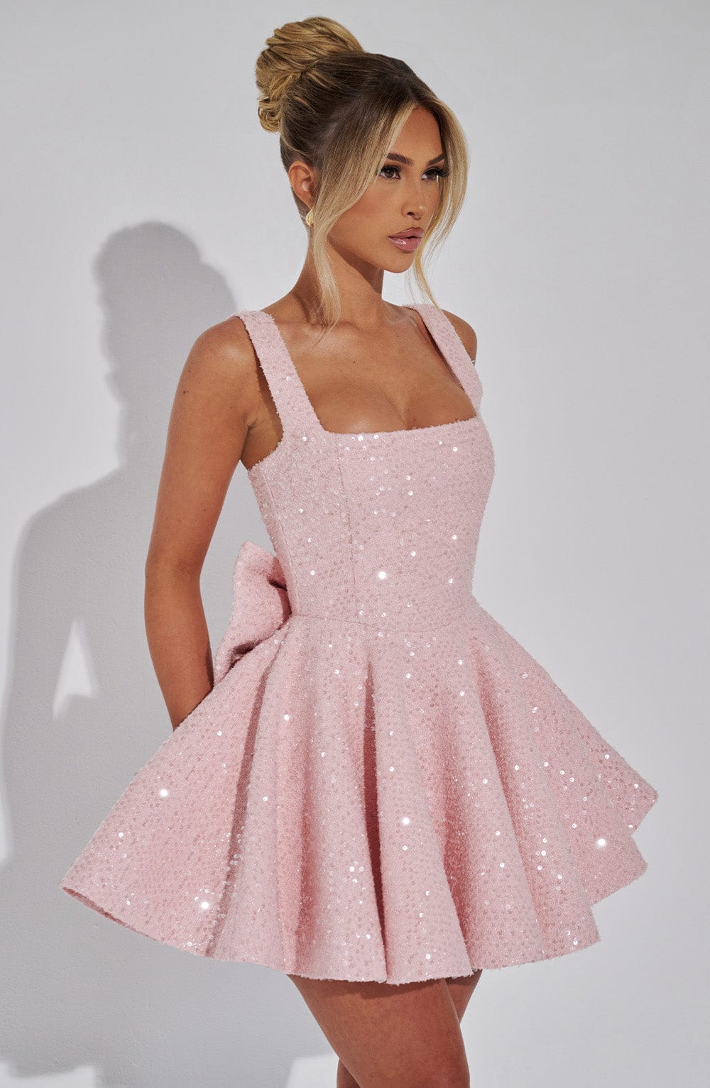 Pink sequin fit & flare mini dress for women, sleeveless, with an elegant back bow for evenings.