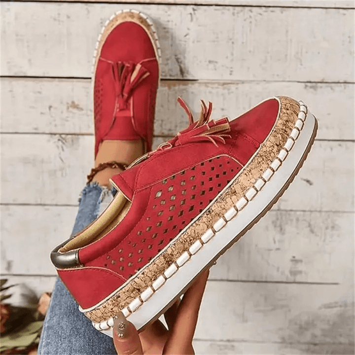 Side view: comfortable women's slip-on sneakers, showing perforated upper and unique tassel detail.