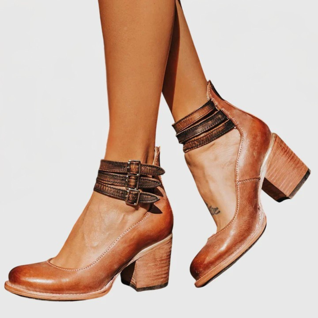 Women's western-inspired ankle boots featuring a sturdy block heel, decorative buckle straps, and chic cutouts.