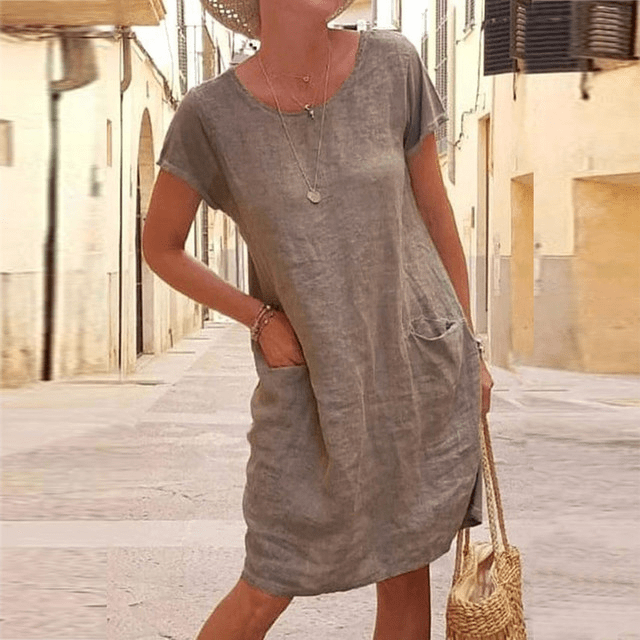 Comfortable women's summer midi dress featuring short sleeves & convenient pockets. Great for warm weather, relaxed fit.