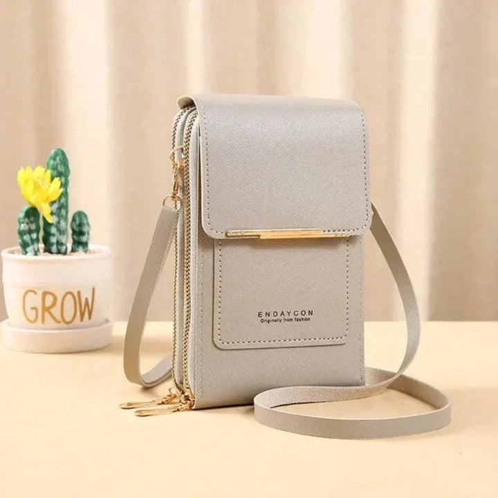 Smart women's touch screen phone crossbody bag, allowing phone use without removal, with adjustable strap.