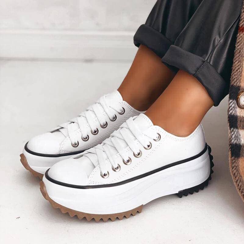 Side profile of chic women's platform sneakers, featuring a thick sole and secure lace-up closure.