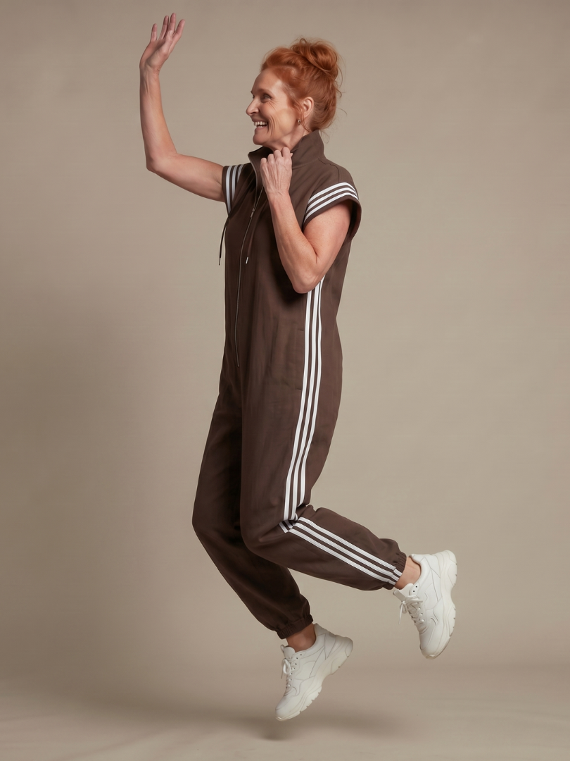 Modern women's one-piece striped jumpsuit with a stylish zip front and cap sleeves.