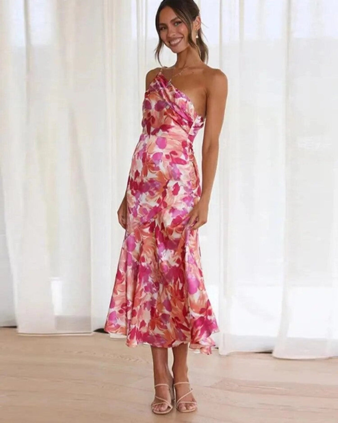 Women's vibrant floral asymmetric midi dress with a flowing hem, perfect for summer parties.