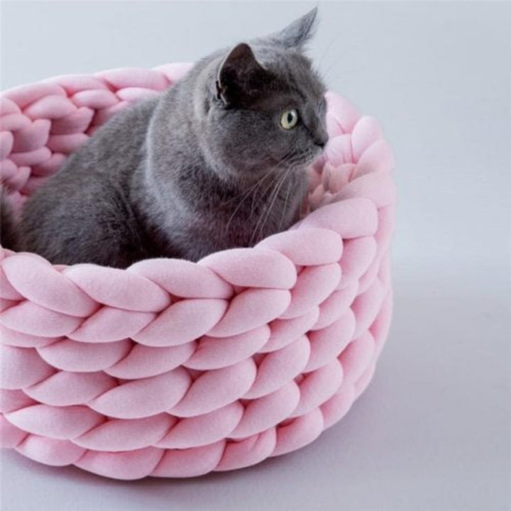 Small dog or cat in a cozy round woven cotton pet bed, hand washable design from Noko Pets.